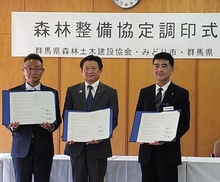 写真：調印書を持つ3者
