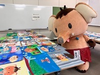 写真：応募作品を眺めるみどモス2024